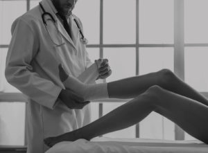 Doctor wrapping injured patients foot