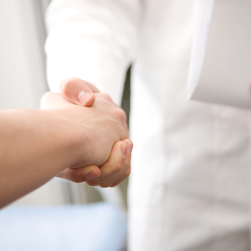 The doctor shaking hands and welcoming a new patient